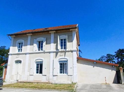 an old white building with a red roof at gite de la gare in Épinouze