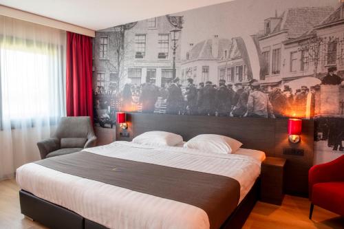 a bedroom with a large bed and a painting on the wall at Bastion Hotel Amersfoort in Amersfoort