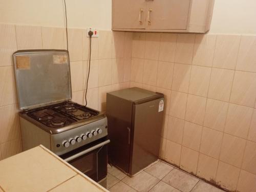 a kitchen with a stove and a refrigerator at Opposite Moran Lounge in Nanyuki