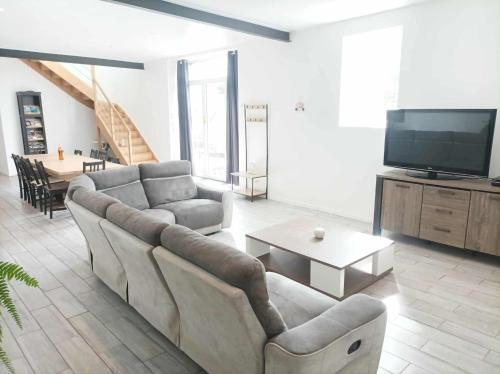 a living room with a couch and a tv at Ti Guernevez - La Longère in Briec