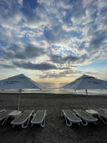 a group of chairs and umbrellas on a beach at Hotel Hawaii in Mamaia