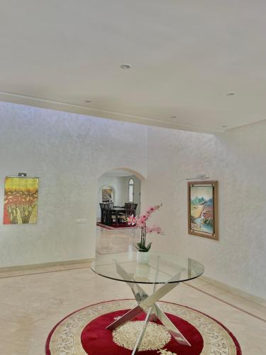 a glass table with a vase on it in a room at villa dar esalam in Rabat