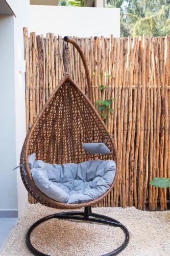a wicker chair sitting in front of a fence at Samawa Living in Paje