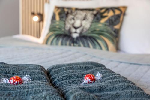 two red strawberries on a bed with a blanket at Annavälla gårdshus in Skurup