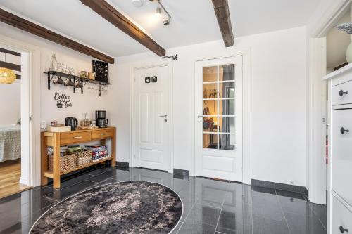 a kitchen with white cabinets and a rug on the floor at Annavälla gårdshus in Skurup
