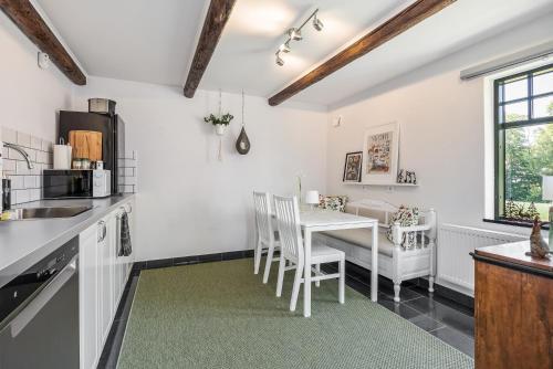 a kitchen and dining room with a table and chairs at Annavälla gårdshus in Skurup