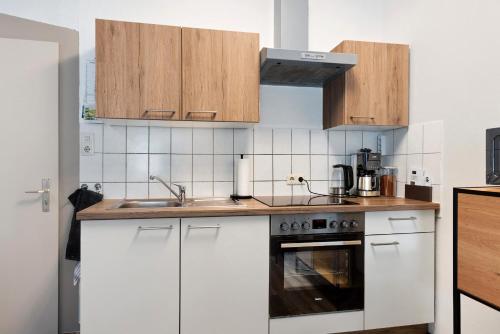 a kitchen with white appliances and wooden cabinets at Casa Doro in Donaueschingen