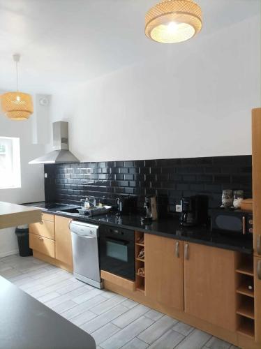 a kitchen with a stove and a counter top at Ti Guernevez - La Longère in Briec