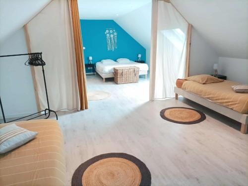 a bedroom with two beds and a blue wall at Ti Guernevez - La Longère in Briec