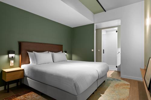 a bedroom with a large white bed and a window at Corendon Apartments Amsterdam Schiphol Airport in Badhoevedorp
