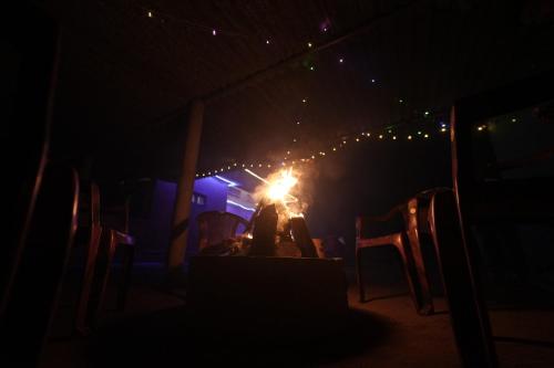 a person sitting at a table with a candle in the dark at Janhavi Homestay in Napoklu