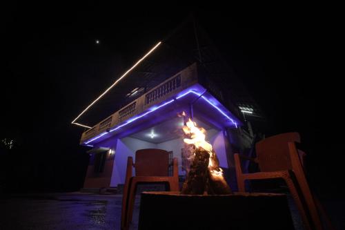 a fire pit in the dark with blue lights at Janhavi Homestay in Napoklu