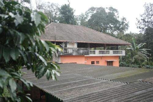 a house with a balcony on top of a roof at Janhavi Homestay in Napoklu