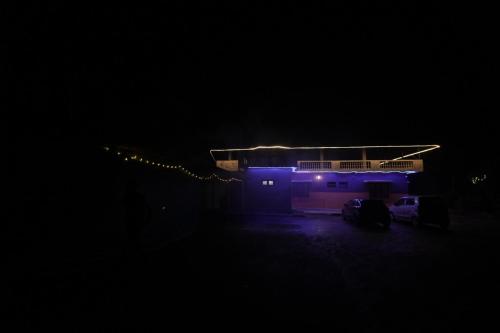 a house with purple lights on it at night at Janhavi Homestay in Napoklu