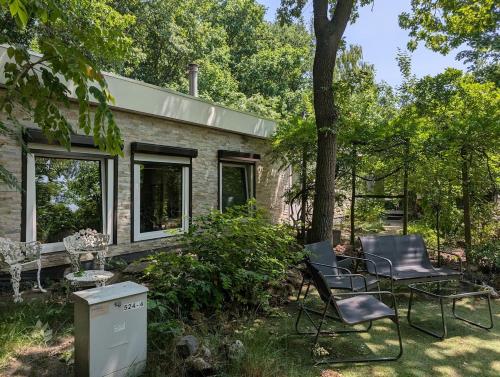 a brick house with two chairs and a table at Heerlijk Huisje Heerle