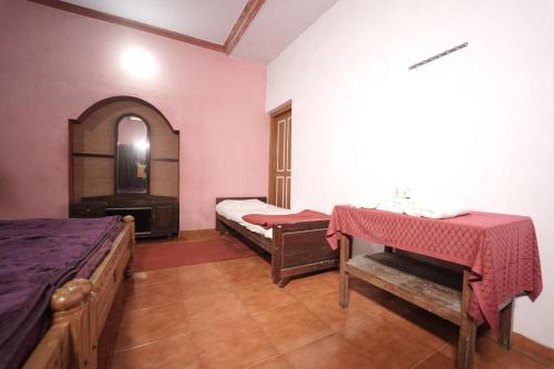 a room with two beds and a table in it at Janhavi Homestay in Napoklu