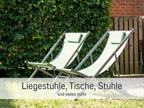 two white lounge chairs sitting in a yard at Kyritzer Budenhäuser Nr 99 - Haus Virginia Peng - Kleinsthaus in Kyritz, einer charmanten Stadt im Herzen von Brandenburg in Kyritz