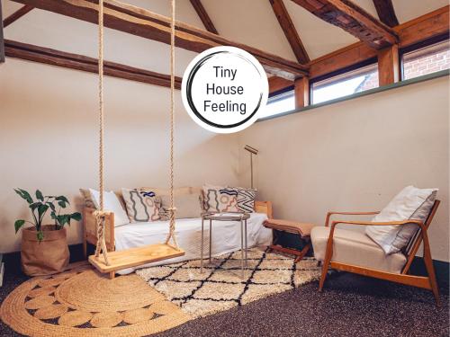 a room with a swing bed and a couch at Kyritzer Budenhäuser Nr 99 - Haus Virginia Peng - Kleinsthaus in Kyritz, einer charmanten Stadt im Herzen von Brandenburg in Kyritz