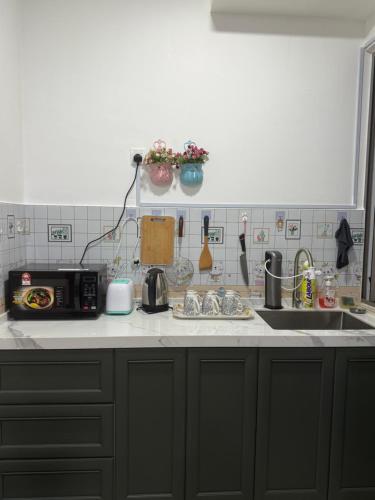 a kitchen counter with a sink and a microwave at Palas Horizon Home A-6-15 in Brinchang