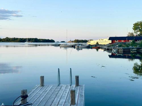 a dock on a lake with boats in the water at Archipelago House With Sea View On Rödlöga in Blidö