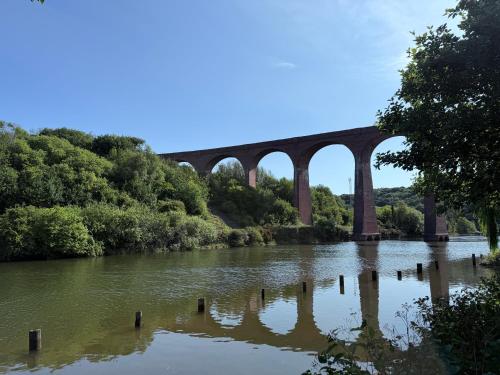a bridge over a river with trees and water at Poppy Cottage - river view, dog friendly in Whitby