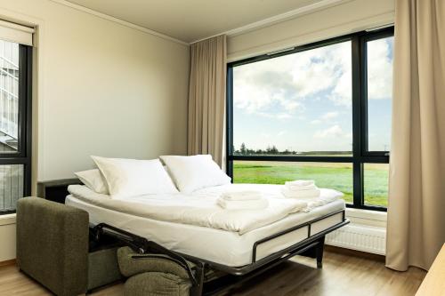 a bed in a room with a large window at Hotel Loa in Hvolsvöllur
