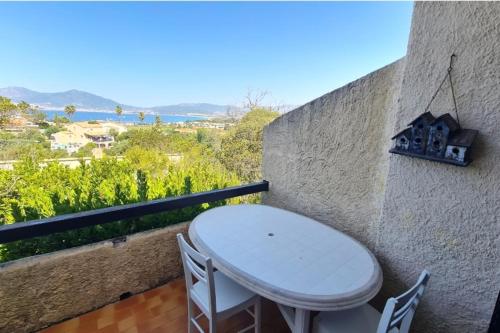 un tavolo bianco e sedie su un balcone con vista di House with pool and tennis court in Porticcio a Grosseto-Prugna
