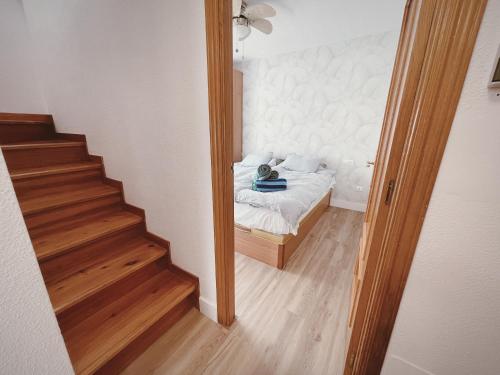 a small bedroom with a bed and a staircase at Casanova 20G Calpe in Calpe