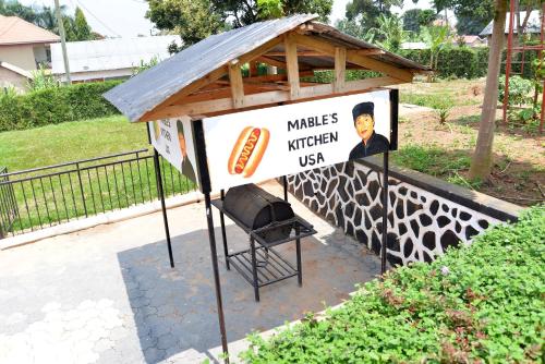 a hot dog stand with a grill and a sign at Aida's Gardens And Mable's Kitchen Entebbe in Entebbe