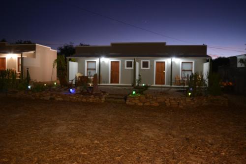 a house with lights in front of it at night at Travellers Rest in Prince Albert