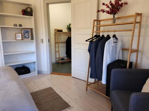 a living room with a closet with clothes on racks at aday - Vejle City Center 1 Bedroom Apartment in Vejle