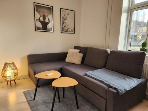 a living room with a couch and two tables at aday - Vejle City Center 1 Bedroom Apartment in Vejle
