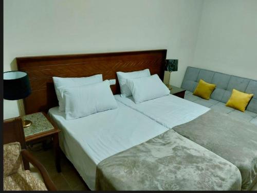 2 camas en una habitación de hotel con almohadas amarillas en قرية أكوا فيو الساحل الشمالي - Aqua View El Alamein, en El Qasaba esh Sharqīya