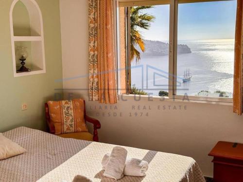 a bedroom with a window with a view of the ocean at Villa Marietta, private pool villa with sea views and terrace, perfect for families and remote stays in Almuñécar