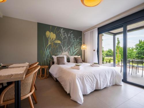 a bedroom with a large bed and a large window at La Ferme d'Estelle in Vulmont