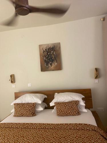 a bed with two pillows and a painting on the wall at Oasis beach resort in Cape Coast