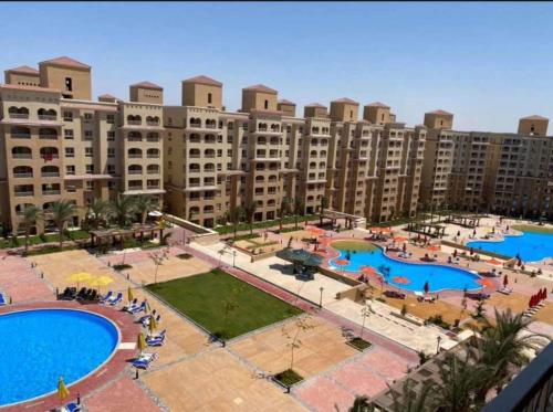 una vista aérea de un gran complejo de apartamentos con 2 piscinas en قرية أكوا فيو الساحل الشمالي - Aqua View El Alamein, en El Qasaba esh Sharqīya