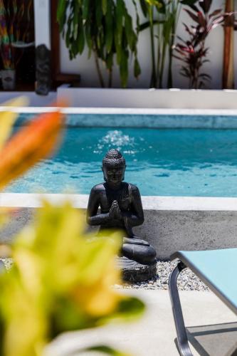 a statue sitting next to a swimming pool at Bali Style Boutique Hotel in Las Terrenas