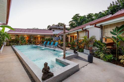 a swimming pool with a statue next to a house at Bali Style Boutique Hotel in Las Terrenas