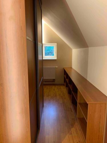 an attic room with a hallway with a shelf and a window at Vila u lesa - Mikulovice in Jeseník