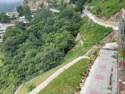 a view of a hill with a road and trees at Timbergrove Villa in Khānspur
