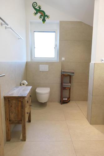 a bathroom with a toilet and a window at Ferienwohnung, 2 Zimmer, 4 bis 6 Personen, 67 qm, mit großem Balkon, entlang am Fluss, an der Aach, am Bodensee, nah am Naturschutzgebiet in Singen
