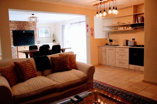 a living room with a couch and a kitchen at Anyskop Guest Farm in Langebaanweg