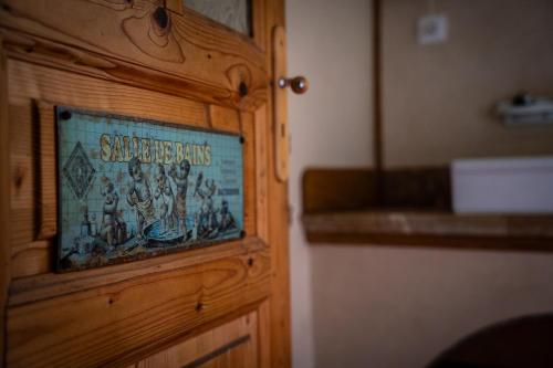 a sign on a wooden door in a room at La Glane at Le Maingaud in Saulgond