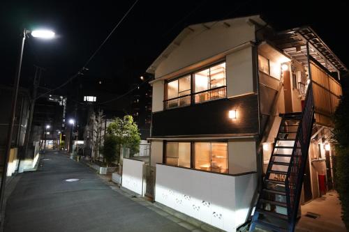 a building with a fire escape on a street at night at tonema in Tokyo