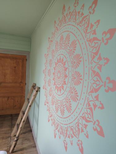 a wall stenciled mandala on a wall at La Glane at Le Maingaud in Saulgond