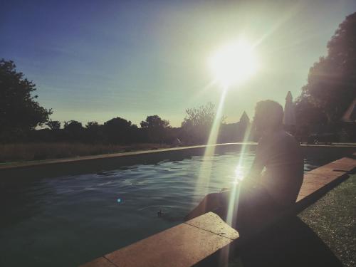 a person sitting on a bench in front of a body of water at La Glane at Le Maingaud in Saulgond