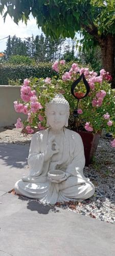 a statue of a person sitting on the ground at Camélias in Laboutarié