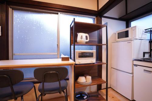 a kitchen with a desk and a microwave and a refrigerator at tonema in Tokyo
