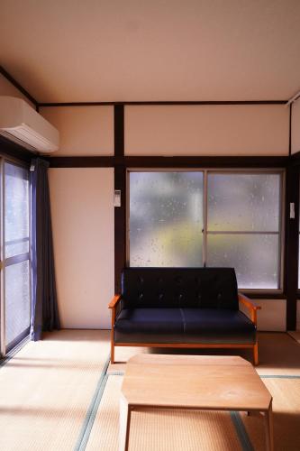 a black couch sitting in front of a window at tonema in Tokyo